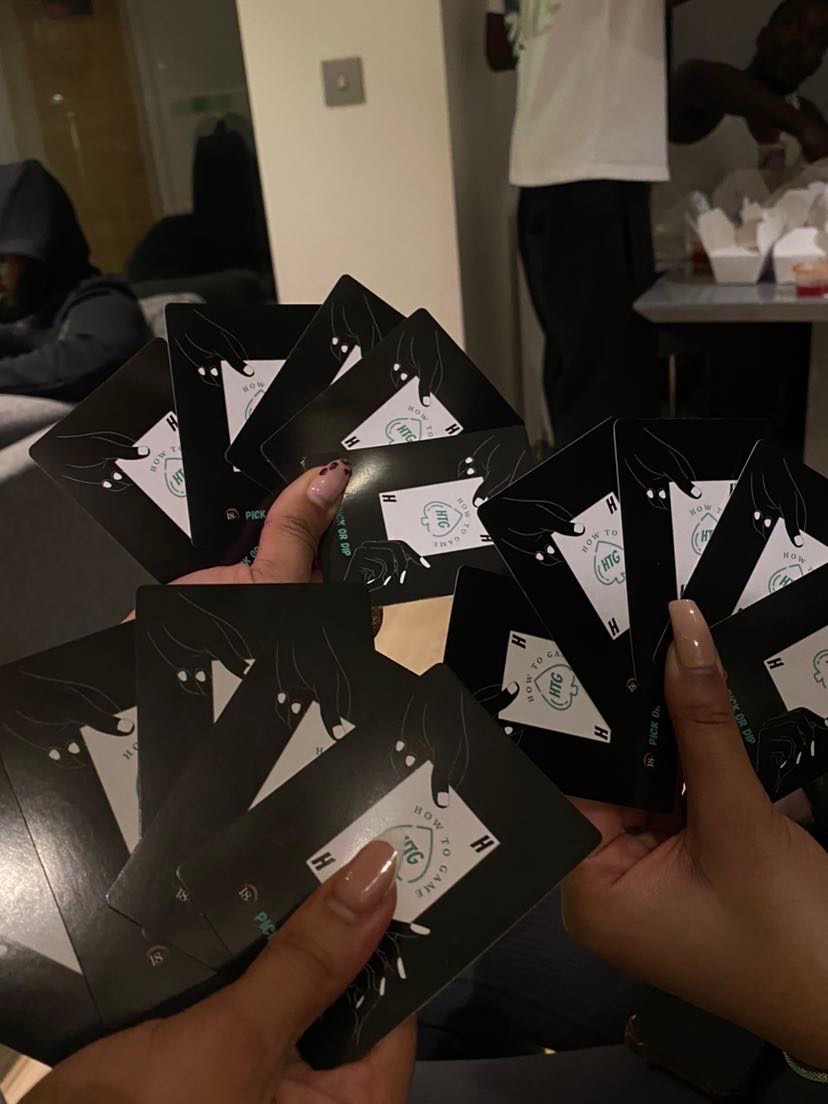 Two players fanning out HowToGame cards at a house party
