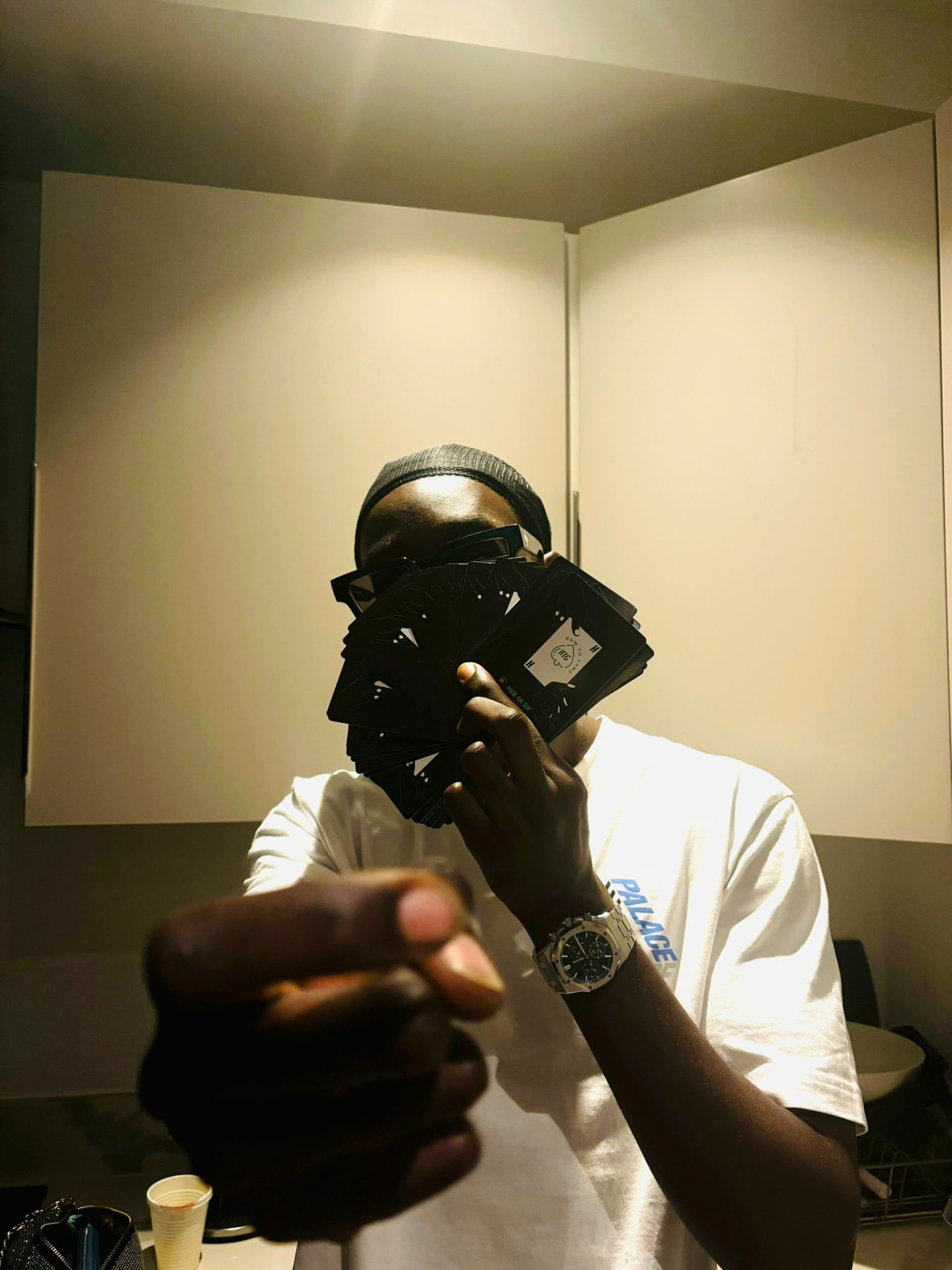 A player holding a fan of HowToGame cards in front of his face